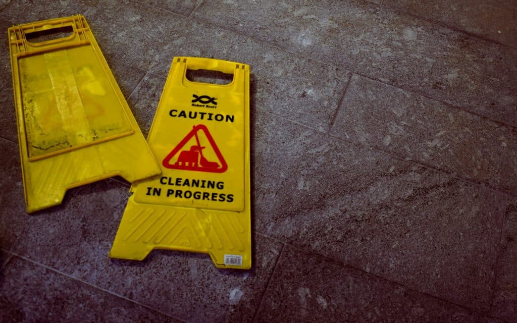 Two yellow floor signs that say caution, cleaning in progress. The company put them up to follow OSHA guidelines.